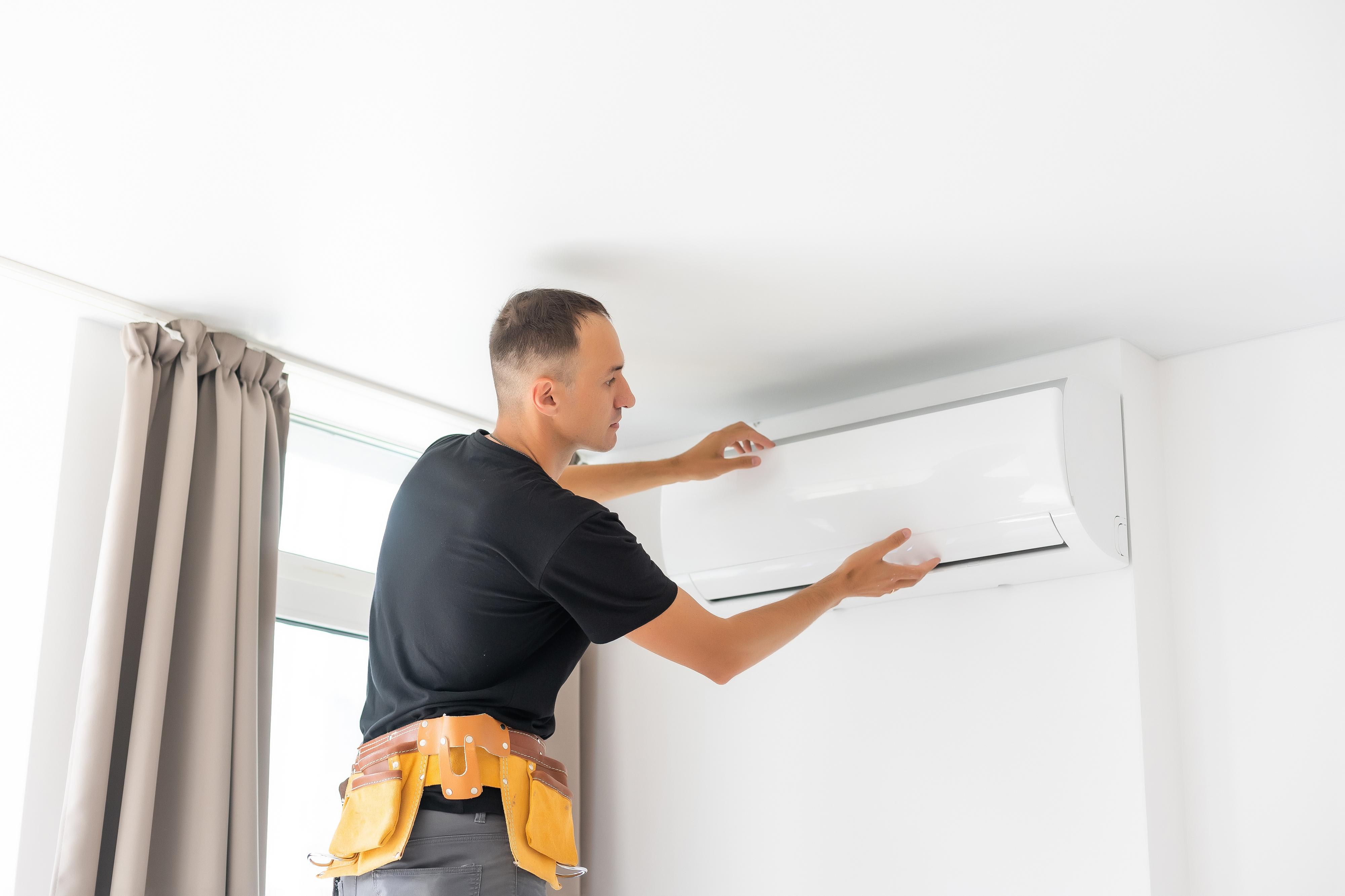 Installateur plaatst airco-binnenunit.